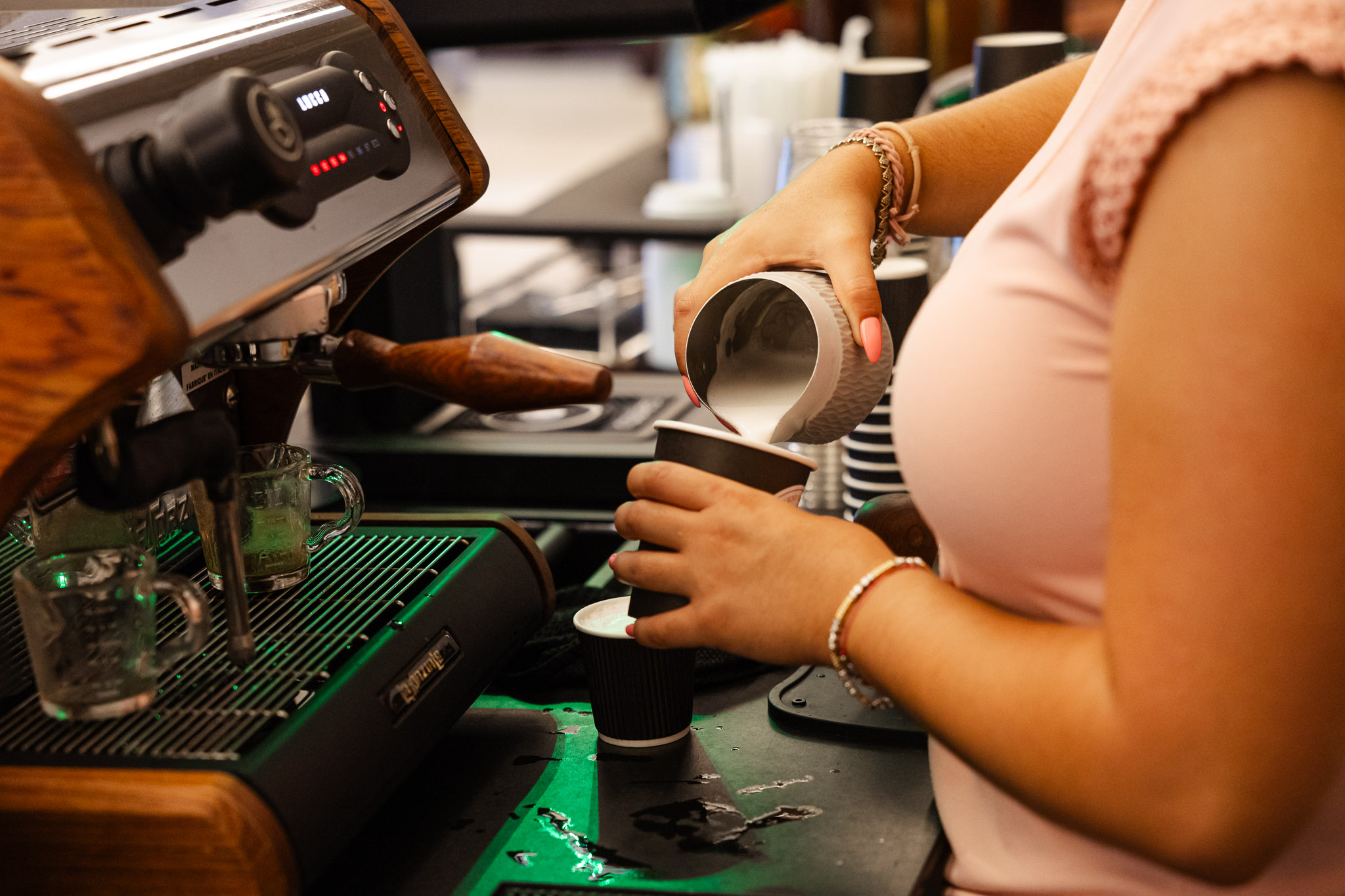 A Coffee Barista making a branded Latte for a customer at a Corporate Conference Event in Miami, Florida.