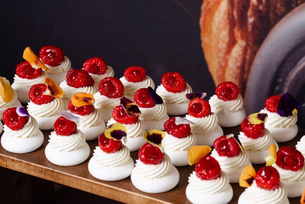Raspberry desserts with edible flowers presented at a Callebaut culinary event