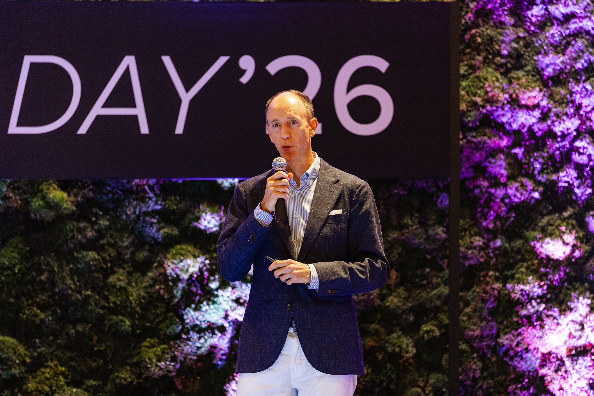 Speaker presenting on stage with dramatic lighting